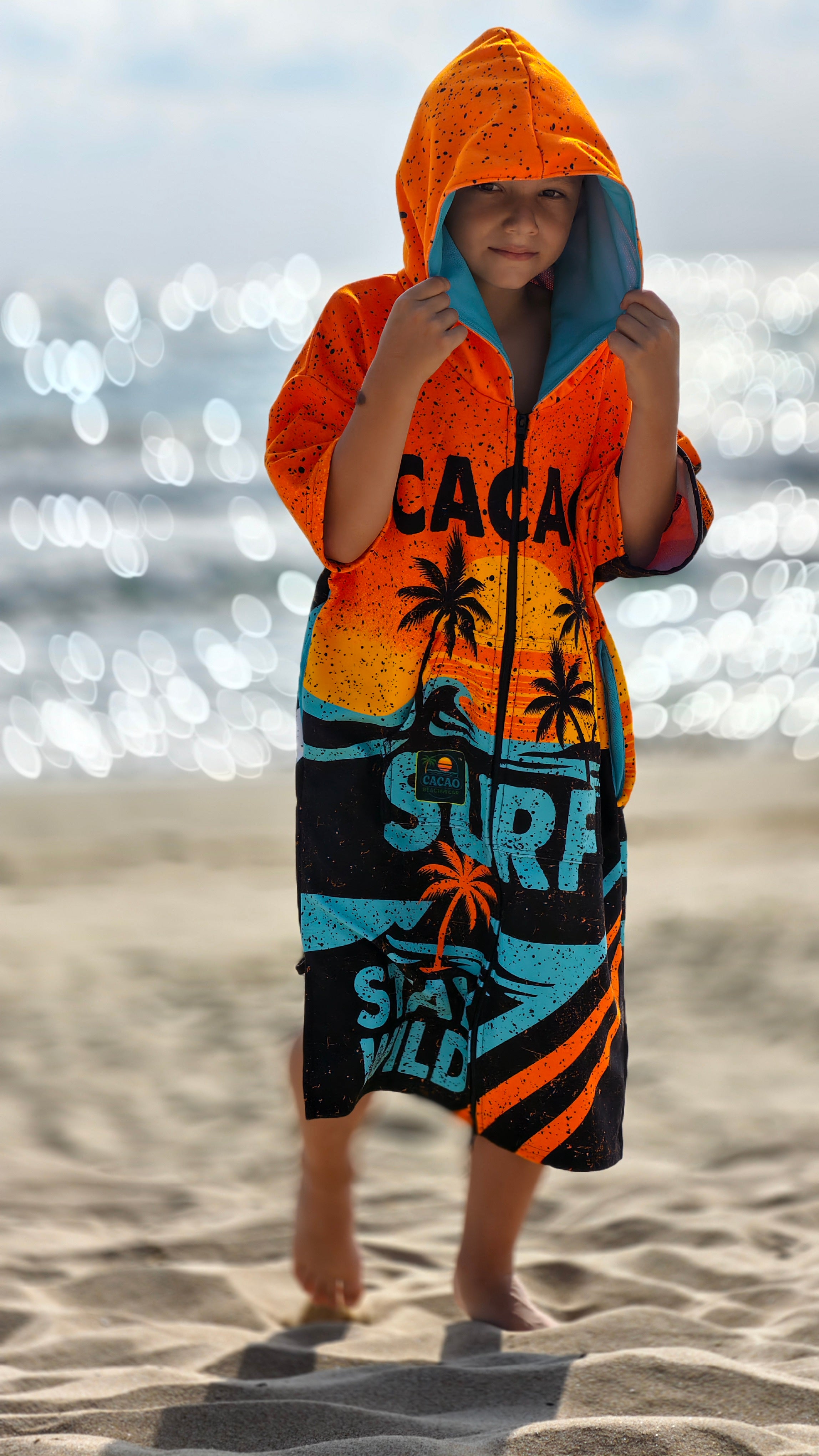 Детска плажна хавлия-пончо в оранжево с качулка, цип и джобове – CACAO Beachwear™